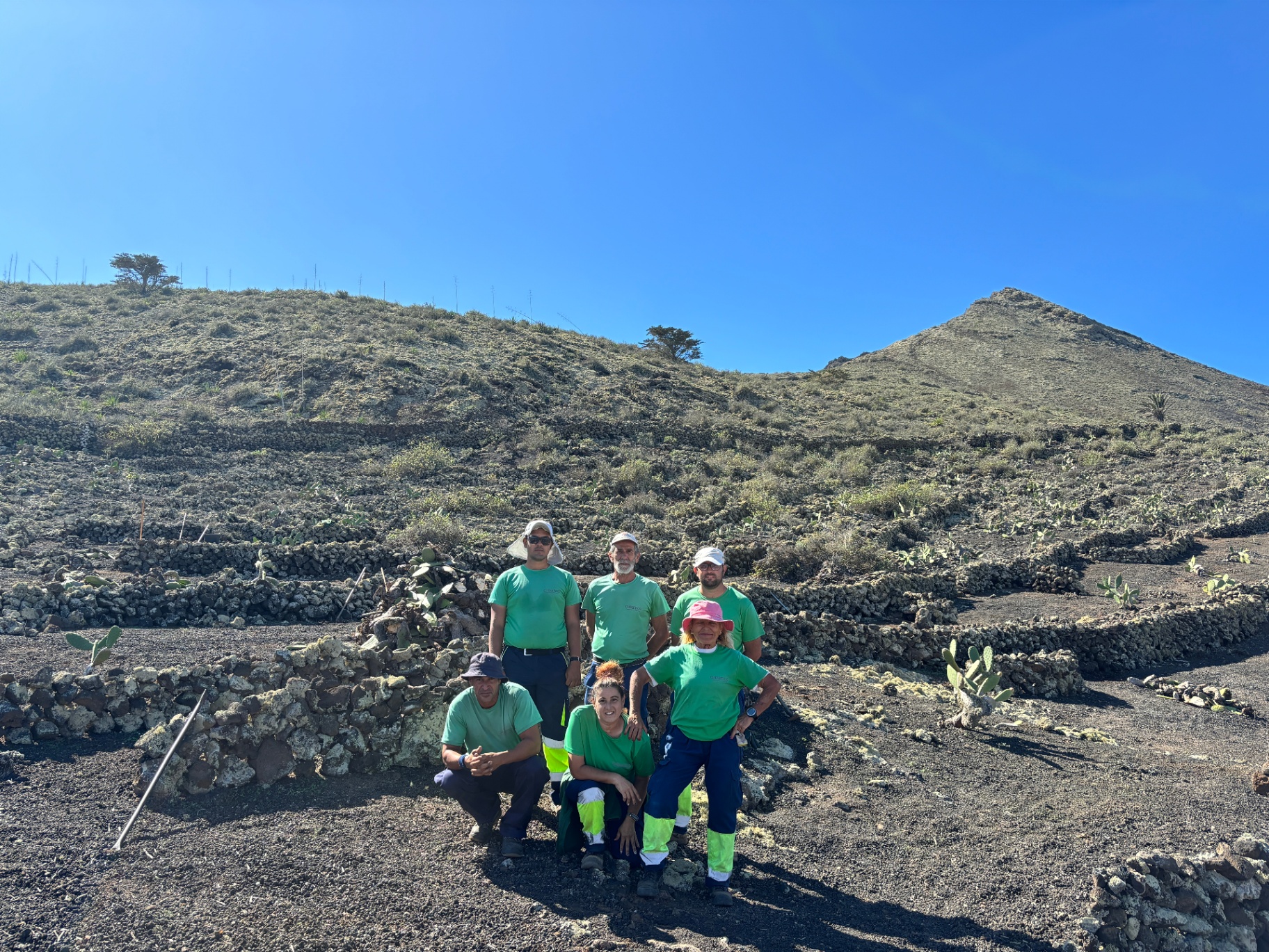 Equipo posando junto a una ladera con cultivo tradicional en Lanzarote