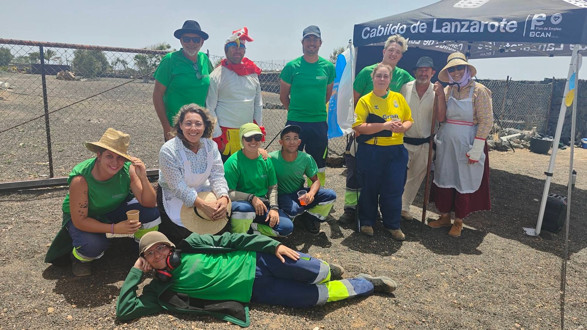 Equipo de trabajadores y trabajadoras sonriendo en una pausa junto a la carpa del Cabildo de Lanzarote